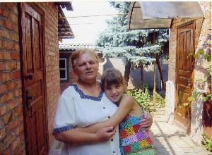 Барсукова Людмила Дмитриевна с внучкой Александрой во дворе своего дома в станице Ленинградской, 2006 г.